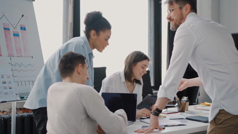 Image of a team collaborating in an office, discussing charts and marketing strategies