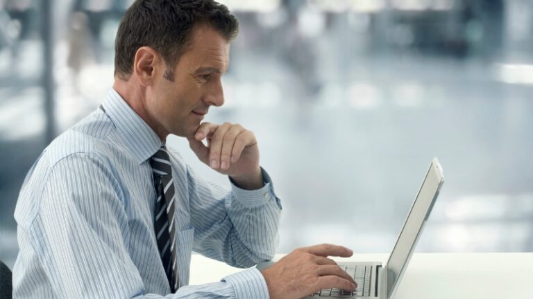 Man using a laptop in an office, browsing free productivity apps
