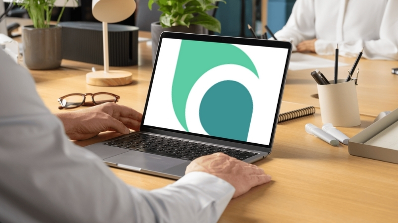 A person using a laptop with the Honestly logo on the screen in a casual office setting