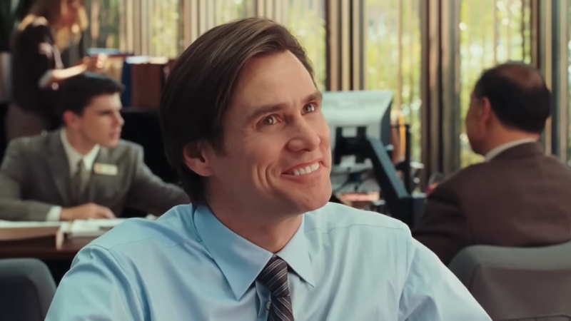 Carl Allen smiles during a conversation at work in a scene from Yes Man (2008)