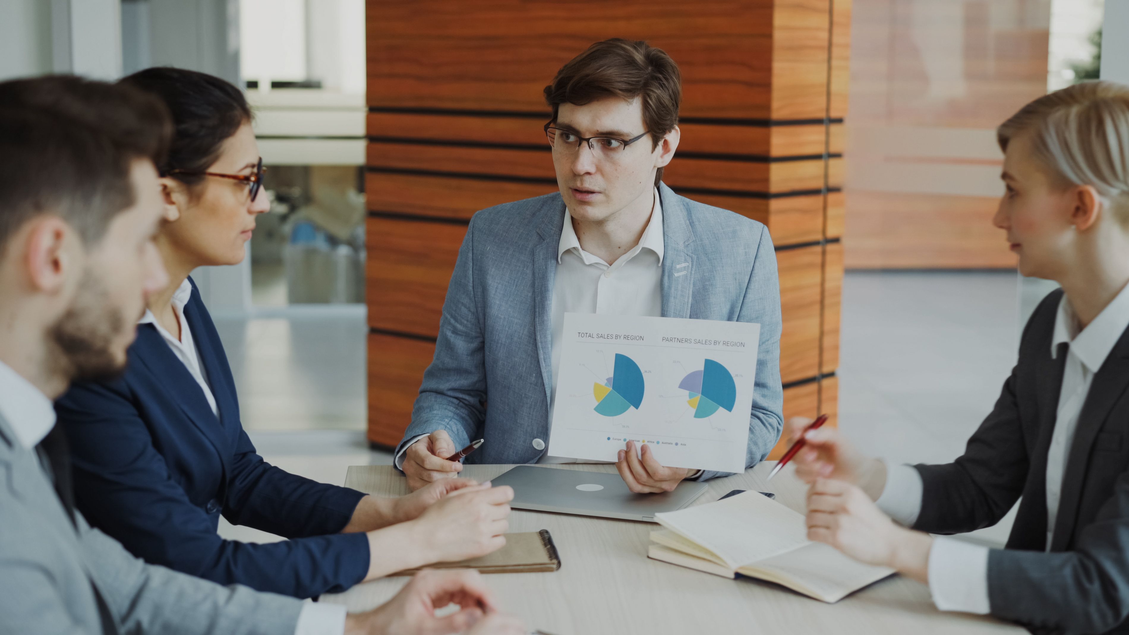 Business team discussing charts and strategy during a meeting, illustrating collaborative HR planning.